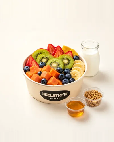 Ensalada de frutas en vaso con yogur natural, granola, miel y algarrobina